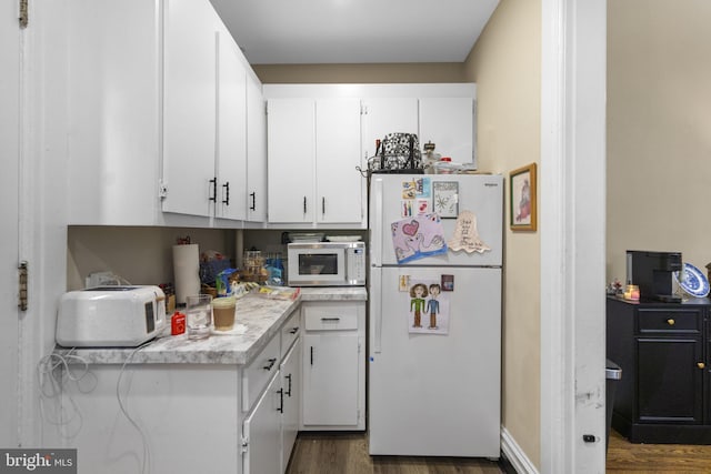 kitchen featuring dark hardwood / wood-style floors, white cabinetry, and white appliances