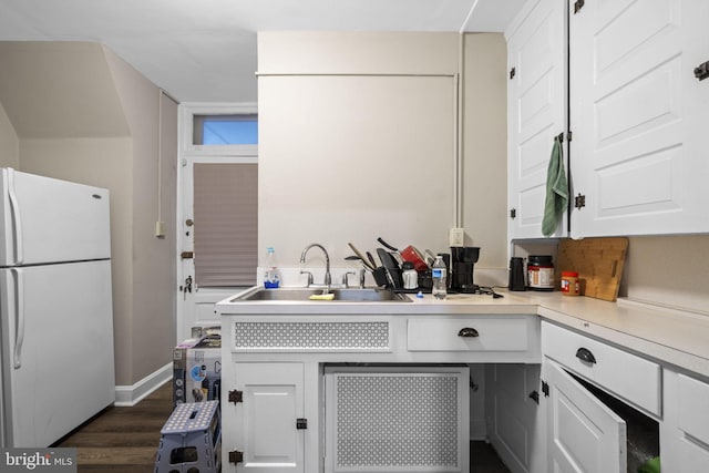 kitchen featuring white cabinets, sink, white fridge, and dark hardwood / wood-style flooring