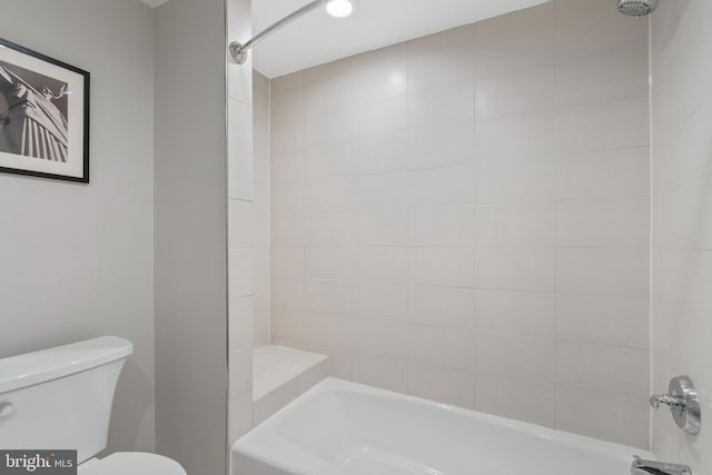 bathroom featuring tiled shower / bath and toilet