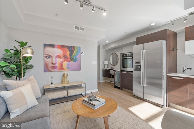 living room featuring sink and light hardwood / wood-style floors