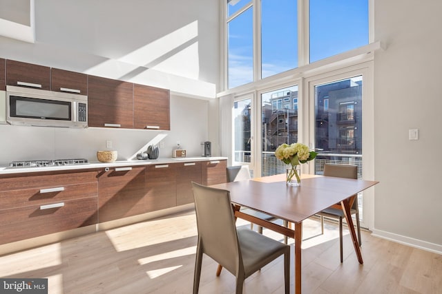 dining area with a high ceiling and light hardwood / wood-style floors