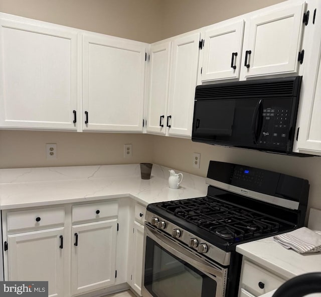 kitchen with white cabinetry, light stone countertops, and stainless steel range with gas stovetop