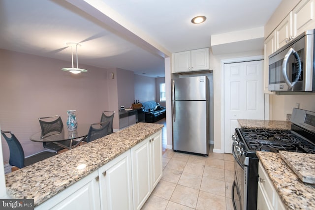 kitchen featuring pendant lighting, light tile patterned floors, light stone counters, white cabinetry, and stainless steel appliances