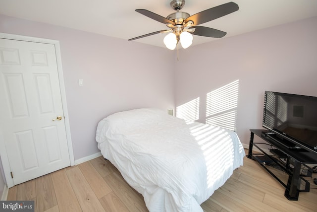 bedroom with light hardwood / wood-style flooring and ceiling fan