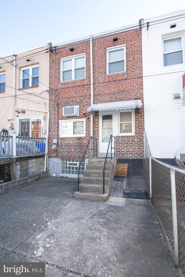 rear view of property with an AC wall unit