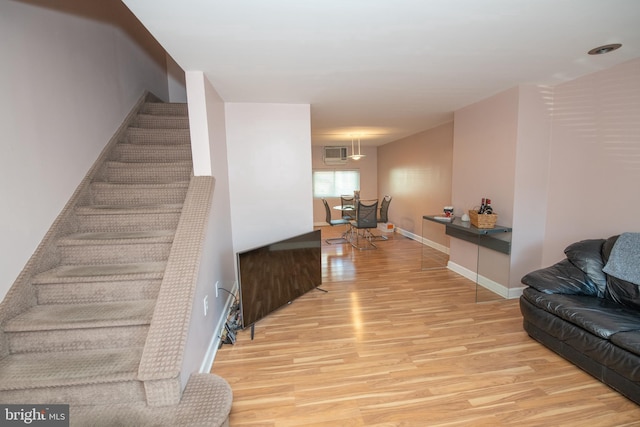 stairway featuring hardwood / wood-style flooring and a wall unit AC