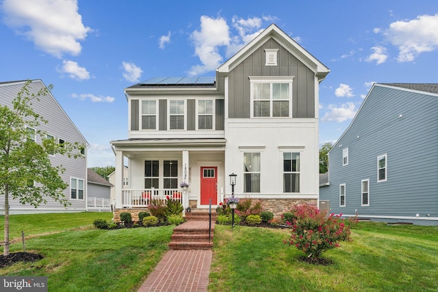 view of front of house featuring covered porch, solar panels, and a front lawn