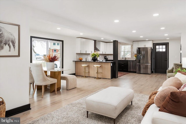 living room with sink and light wood-type flooring