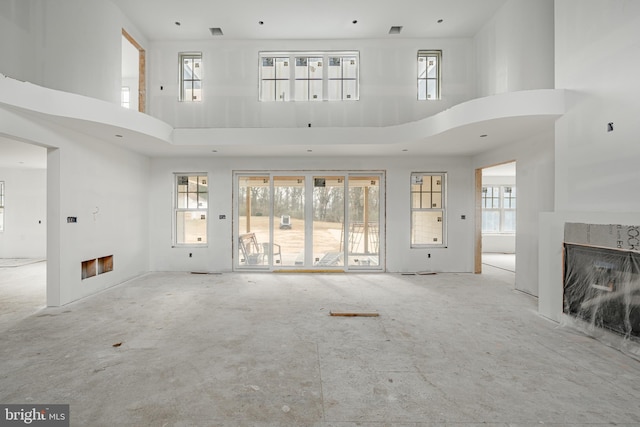 unfurnished living room with a towering ceiling