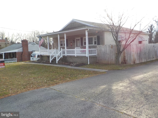 view of front of property featuring a front yard and covered porch