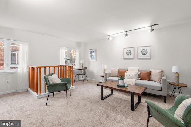 living room with a wealth of natural light, rail lighting, and light carpet