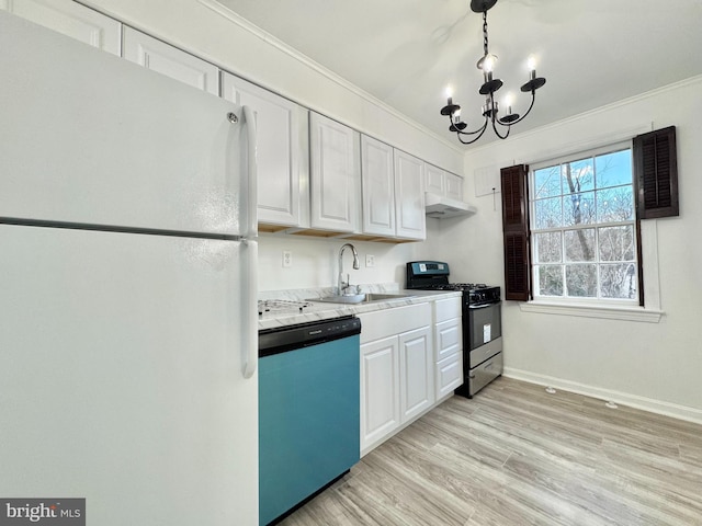 kitchen with appliances with stainless steel finishes, ornamental molding, sink, a notable chandelier, and white cabinetry