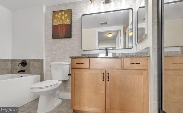 bathroom featuring a bathtub, vanity, tile walls, tile patterned flooring, and toilet