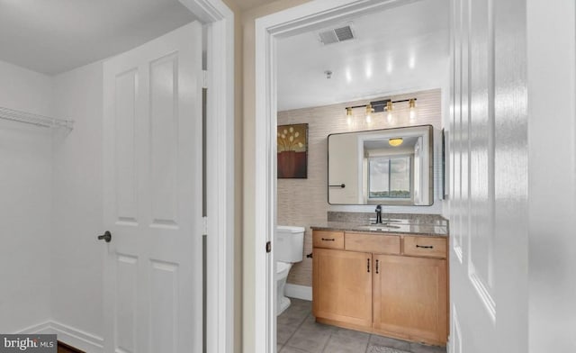 bathroom featuring tile patterned floors, vanity, and toilet