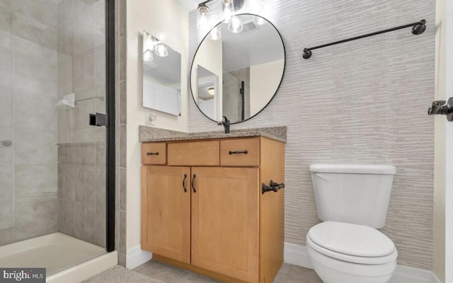 bathroom featuring tile patterned flooring, vanity, toilet, and a shower with shower door