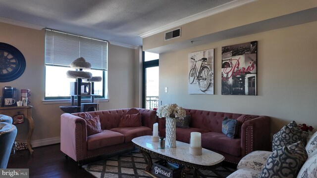 living room with a healthy amount of sunlight, dark hardwood / wood-style flooring, a textured ceiling, and crown molding