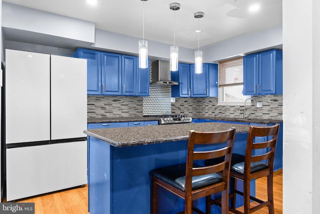 kitchen with a kitchen island, a breakfast bar, blue cabinets, white refrigerator, and light hardwood / wood-style floors