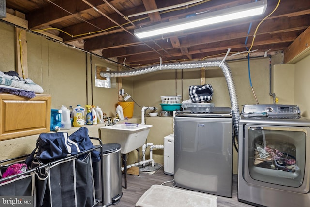 washroom with independent washer and dryer, sink, and hardwood / wood-style floors