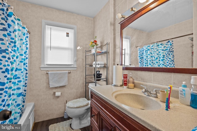 bathroom featuring tile walls, vanity, wood-type flooring, and toilet