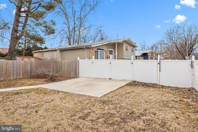 rear view of property featuring a yard and a patio area