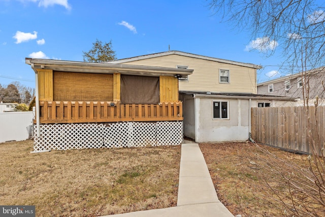 view of front of home with a wooden deck and a front yard