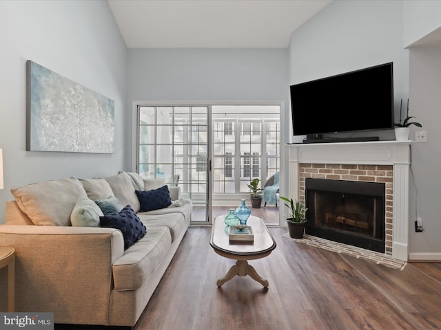 living room with hardwood / wood-style floors and a brick fireplace