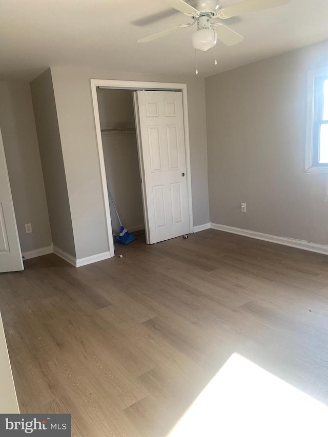 unfurnished bedroom with hardwood / wood-style floors, a closet, and ceiling fan