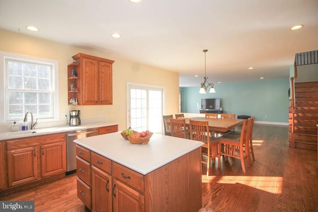 kitchen with dishwasher, sink, hanging light fixtures, a kitchen island, and dark hardwood / wood-style flooring