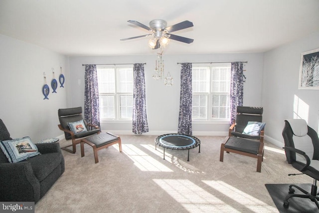 living area with light colored carpet, plenty of natural light, and ceiling fan