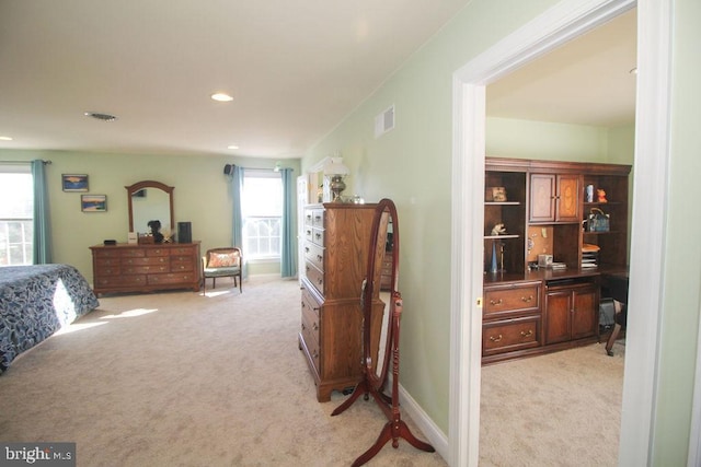 bedroom featuring light colored carpet and multiple windows