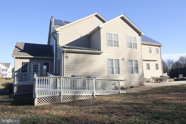 rear view of property with a lawn, a patio area, and a deck