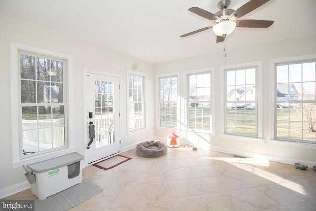 unfurnished sunroom with ceiling fan