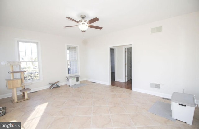 tiled empty room featuring ceiling fan