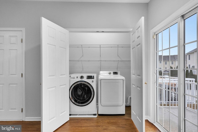 laundry area with hardwood / wood-style floors and washing machine and clothes dryer