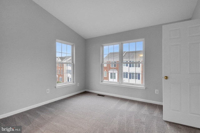 empty room featuring carpet floors and vaulted ceiling