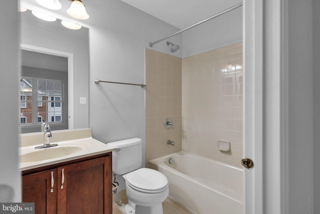 full bathroom featuring tile patterned flooring, vanity, tiled shower / bath combo, and toilet