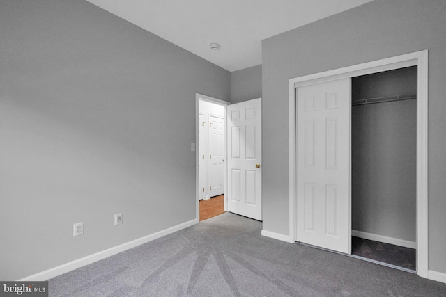 unfurnished bedroom featuring carpet and a closet