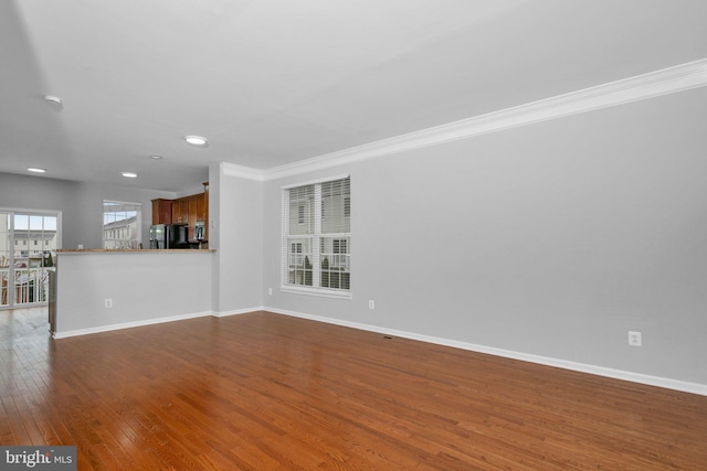 unfurnished living room with dark hardwood / wood-style flooring and ornamental molding