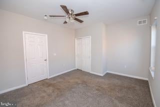 carpeted spare room with ceiling fan