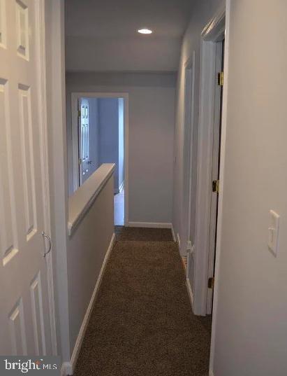 corridor with dark colored carpet