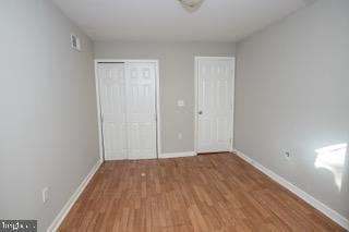 unfurnished bedroom with wood-type flooring and a closet