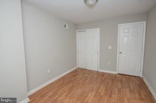 unfurnished bedroom featuring wood-type flooring and a closet