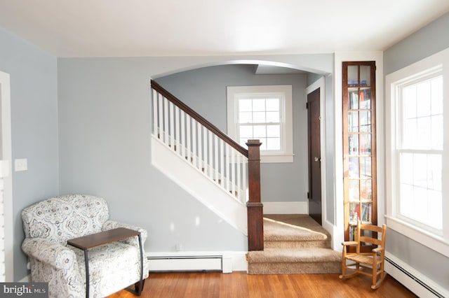 entrance foyer with baseboard heating, plenty of natural light, and light wood-type flooring