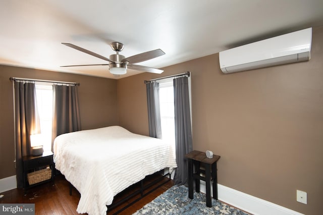 bedroom with ceiling fan, dark hardwood / wood-style floors, and a wall mounted AC