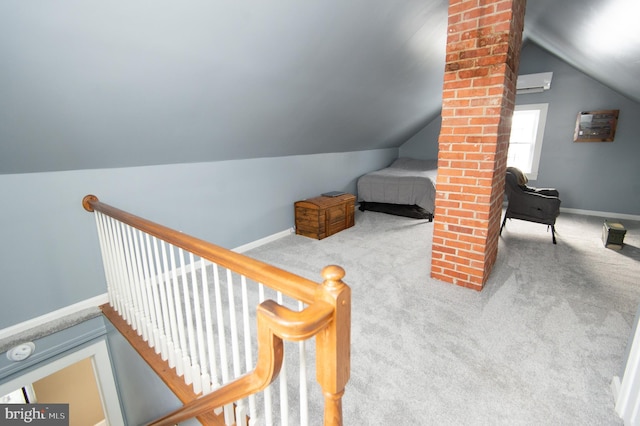 interior space with carpet floors, vaulted ceiling, and a wall mounted AC