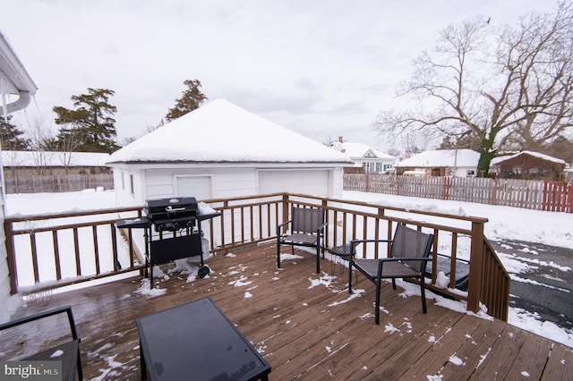 snow covered deck featuring an outdoor structure, area for grilling, and a garage