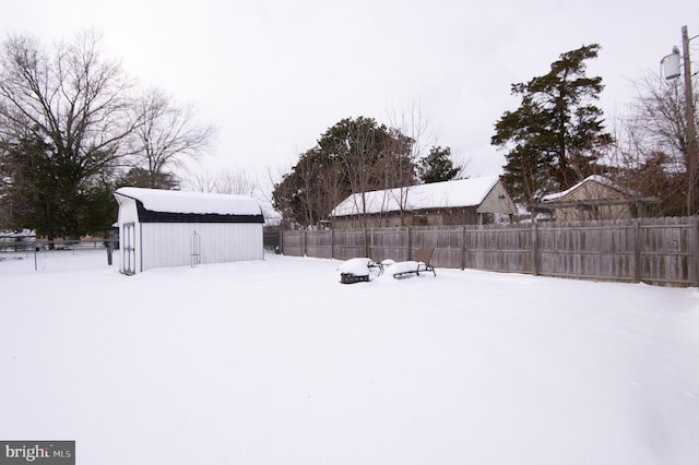 snowy yard featuring an outbuilding