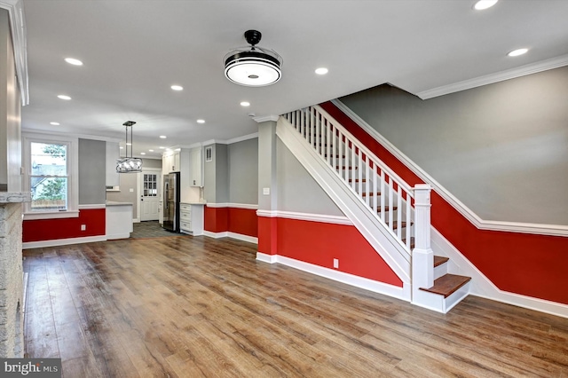 unfurnished living room with hardwood / wood-style floors and ornamental molding