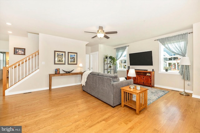 living room featuring light hardwood / wood-style floors and ceiling fan