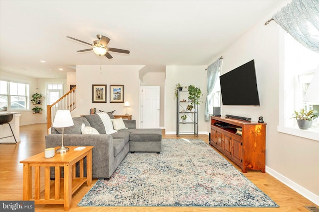 living room with light hardwood / wood-style floors and ceiling fan